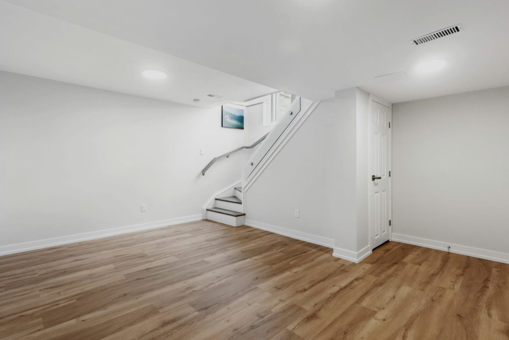 Une pièce vide avec un escalier et un sol en bois