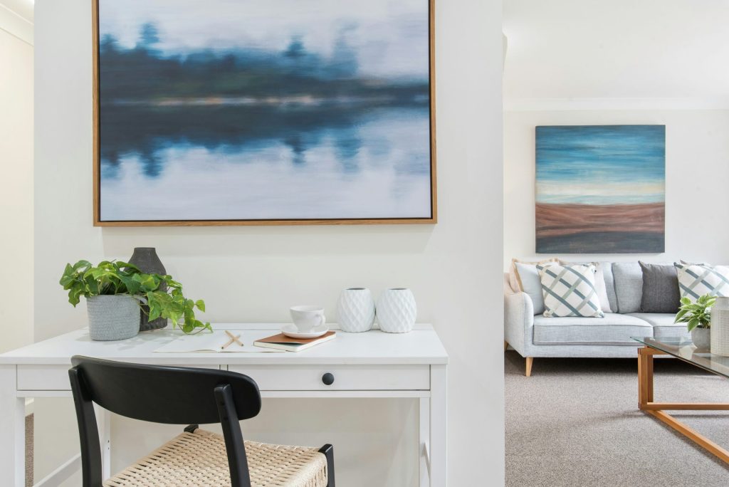 Table blanche et noire avec des chaises près d'une peinture représentant un plan d'eau